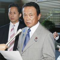 Finance Minister Taro Aso speaks to reporters Thursday after a Cabinet meeting. Cabinet guidelines set limits on social security spending for fiscal 2018
