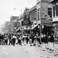 Hundreds of people run down 12th Street on Detroit\'s west side throwing stones and bottles at storefronts in July 1967. The riot started after police raided an after-hours club in a predominantly African-American neighborhood. The raid, though, was just the spark. Many in the community blamed frustrations blacks felt toward the mostly white police, and city policies that pushed families into aging and overcrowded neighborhoods. | AP