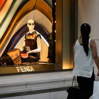 A shopper walks past a window display in a Fendi store, a brand of LVMH, in the Ginza district of Tokyo. | BLOOMBERG
