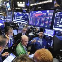 Specialist Peter Giacchi (background, center) handles the close of trading of Reynolds American on the floor of the New York Stock Exchange on July 24. | AP