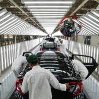 Employees check Honda Civic vehicles at the quality control station on the production line at Honda Motor Co.\'s assembly plant in Prachinburi, Thailand. | BLOOMBERG