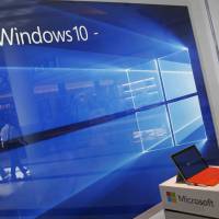 A display for the Windows 10 operating system is seen in a store window of the Microsoft store at Roosevelt Field in Garden City, New York, in 2015. Microsoft plans sales force layoffs as it shifts from software to cloud computing