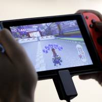 A person plays Nintendo\'s \"Mario Kart 8 Deluxe\" video game on a Switch console. | BLOOMBERG