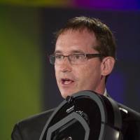 Colin Angle, chairman, chief executive officer and co-founder of iRobot Corp., holds up a Roomba robot in 2013. SoftBank Group Corp. is said to have taken a stake in the company. SoftBank takes stake in Roomba-maker iRobot as part of tech grab: sources