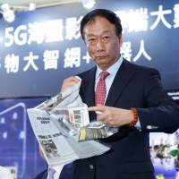 Terry Gou, founder and chairman of Foxconn, tears a newspaper bearing a front page article about Foxconn losing the acquisition battle for Toshiba Corp.\'s chip business, during a news conference in Taipei on June 22. | REUTERS