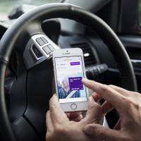 A driver for the Uber Technologies Inc. ride-hailing service uses the company’s app on a smartphone in Singapore. Uber in the crosshairs as Japan's SoftBank helps rivals raise $9 billion