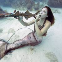 Mariah Reynolds pretends to play a local artist’s musical instrument sculpture on Saturday at the Lower Keys Underwater Music Festival in the Florida Keys National Marine Sanctuary off Big Pine Key. Underwater music festival held at Florida reef