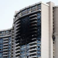 The charred exterior of the Marco Polo Building is pictured after a fire broke out on the upper floors in Honolulu Friday. At least three people were killed and a dozen injured when the massive fire tore through a 36-story apartment complex, local media reported. Despite recommendation, Honolulu high-rise failed to update fire alarm system