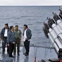 Indonesian President Joko \"Jokowi\" Widodo (third right) and other officials stand on the deck of navy warship KRI Imam Bonjol, in the waters off the country\'s Natuna Islands on June 23. | AP