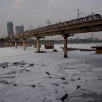 A train crosses a bridge over the polluted Yamuna River in New Delhi on July 3. Rivers do not have same rights as humans, India's top court rules