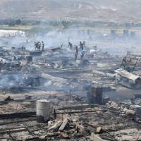Civil defense members and civilians put out fire at a camp for Syrian refugees near the town of Qab Elias, in Lebanon’s Bekaa Valley, Sunday. Fire reduces Syrian refugee camp to ashes in Lebanon; one dead