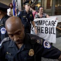 Capitol Hill police prepare to arrest a group protesting the republican health care bill outside the offices of Nevada Republican Sen. Dean Heller on Capitol Hill in Washington on Monday. Two more GOP senators oppose health bill, killing it for now