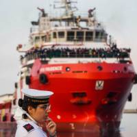 An Italian Coast Guardsman waits as the NGO Medecins Sans Frontier Vos Prudence ship carrying more than 900 migrants rescued at sea comes in to dock at Salerno\'s harbor Friday. | CESARE ABBATE / ANSA / VIA AP