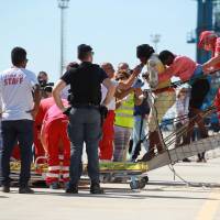Two migrant women are helped off the Spanish NGO ship Open Arms at the Sicilian port of Porto Empedocle, southern Italy, after being rescued at sea, Thursday. According to reports, there are 10 ships that are currently heading to Italian ports, with aboard more than 7,300 migrants saved off the coast of Libya over the past few days. Italy pitches Libya pact to curb illegal migration flood, urges crackdown on smugglers in restive south