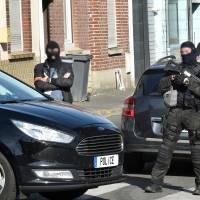 Police officers of an anti-terrorim unit and of French intelligence agency (DGSI) patrol a street in Wattignies, northern France, after a man was arrested during a French-Belgian anti-terrorist operation Wednesday. Four people have been arrested and an arms cache found after overnight terror raids in Brussels linked to a bikers\' club called the Kamikaze Riders, federal prosecutors said Wednesday. | AFP-JIJI
