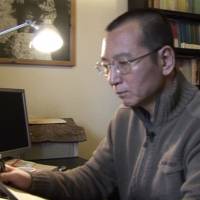 Liu Xiaobo looks at documents in his home in Beijing on Jan. 6, 2008. Chinese Nobel winner Liu Xiaobo in final stages of cancer: hospital