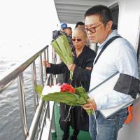 This handout photo provided by the Shenyang Municipal Information Office shows the late Nobel laureate Liu Xiaobo’s wife, Liu Xia, and her younger brother, Liu Xiaoxuan, holding flowers as they bury Liu’s ashes at sea off the coast of Dalian, Liaoning Province, on Saturday. The body of China’s late Nobel laureate Liu Xiaobo was cremated after a private ceremony attended by his wife and friends, two days after the dissident lost a battle with cancer while in custody. Friends worry over fate of Chinese dissident Liu's widow, demand her release