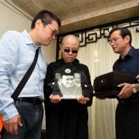 Liu Xia, wife of deceased Chinese Nobel Peace Prize-winning dissident Liu Xiaobo, holds his picture during his funeral in Shenyang, China, on Saturday. China says Nobel laureate Liu has been cremated, wife is 'free'