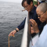 Liu Xia, wife of deceased Chinese Nobel Peace Prize-winning dissident Liu Xiaobo, attends his sea burial with other relatives off the coast of Dalian, China, on Saturday. Chinese dissident Liu Xiaobo's ashes buried at sea amid Beijing's apparent attempt to prevent pilgrimage site