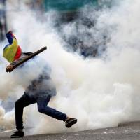 A demonstrator clashes with riot security forces during a rally against Venezuelan President Nicolas Maduro\'s government in Caracas Saturday. | REUTERS