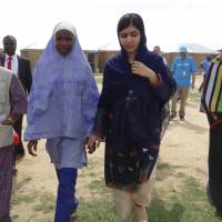 Pakistani activist Malala Yousafzai (center right) is welcomed by students and a staff from UNICEFF during a visit to the camp of people displaced by Islamist extremists in Maiduguri ,Nigeria, Tuesday. Nobel Peace Prize laureate Malala was greeted with cheers Tuesday by dozens of young women in northeastern Nigeria, where she spoke out for the many girls abducted under Boko Haram’s deadly insurgency. Malala slams China over death of fellow Nobel laureate Liu Xiaobo, faults Nigeria on education
