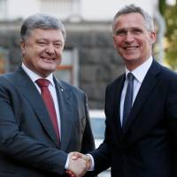 Ukrainian President Petro Poroshenko (left) shakes hands with NATO Secretary-General Jens Stoltenberg before a meeting in Kiev on Monday. | REUTERS