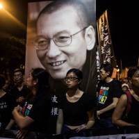 People attend a march for the late Chinese Nobel laureate Liu Xiaobo in Hong Kong on Saturday. | AFP-JIJI