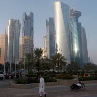 A man walks along the corniche in Doha, Qatar, last month. Qatar is one of the world’s richest nations. At talks in Cairo, Qatar rivals look to next move to end Persian Gulf crisis