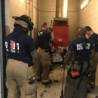 Emergency personnel respond to a call from a man who was stuck in a trash chute, early Sunday in Washington. Spokesman Vito Maggiolo says the man was throwing out trash at the apartment building when he thought he dropped a cellphone in the chute. Maggiolo says the man leaned in to check and fell inside. Man looking for cellphone falls into Washington apartment trash chute
