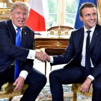 French President Emmanuel Macron (right) welcomes U.S. President Donald Trump at the Elysee Palace in Paris Thursday. Trump calls son's Russia meeting 'standard campaign practice'