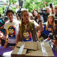 Lilian Tintori, wife of Venezuela’s currently-under-house-arrest opposition leader Leopoldo Lopez, casts her vote at a polling station in Caracas on Sunday during an opposition-organized vote against Venezuelan President Nicolas Maduro’s plan to rewrite the constitution. Authorities have refused to greenlight the vote that has been presented as an act of civil disobedience and supporters of Maduro are boycotting it. Maduro foes across Venezuela, expats worldwide cast plebiscite ballots against constitution rewrite