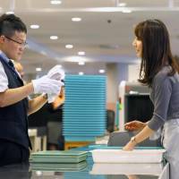 An airport security worker checks a passenger\'s luggage during a training session last month at Narita airport. | KYODO