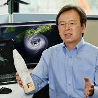 Nagoya University professor Kazuhisa Tsuboki explains his team’s project to analyze supertyphoons, holding an expendable device for collecting data on temperatures, air pressure and wind speeds in typhoons. Nagoya University team to use aircraft to gauge potency of supertyphoons