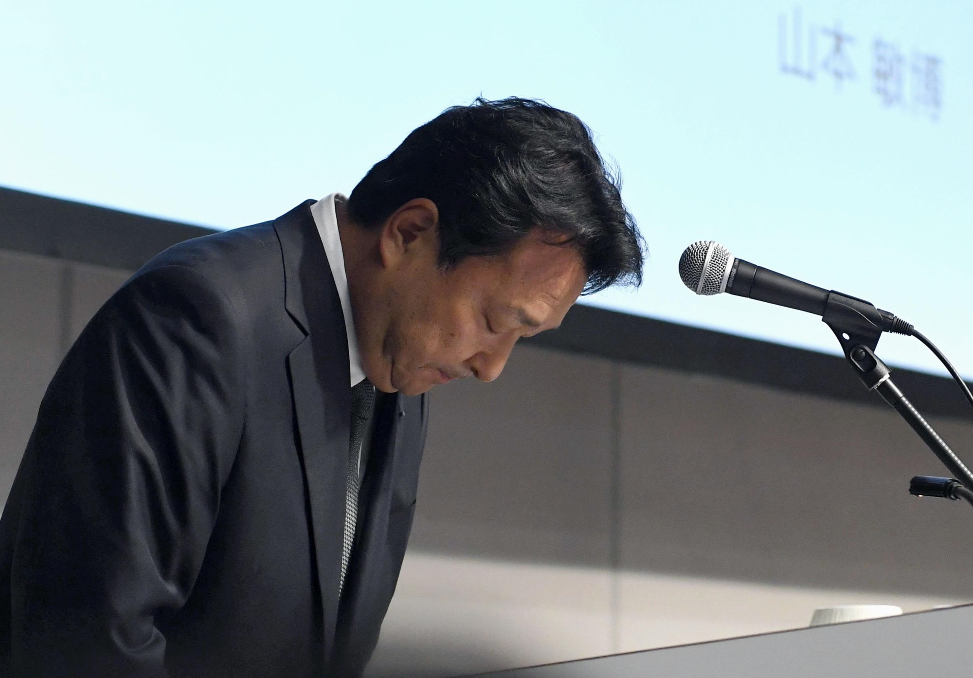 Dentsu President Toshihiro Yamamoto apologizes at a news conference in Tokyo on Thursday. | KYODO