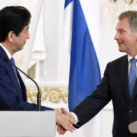 Prime Minister Shinzo Abe and Finnish President Sauli Niinisto shake hands during a joint news conference at the Presidential Palace in Helsinki on Monday. | AFP-JIJI