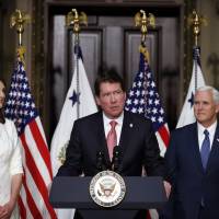 Vice President Mike Pence (right) stands as William F. Hagerty IV speaks with his wife Chrissy Hagerty after Hagerty was sworn in to be U.S. Ambassador to Japan, in the Indian Treaty Room of the Eisenhower Executive Office Building in the White House complex on July 27, 2017. U.S. Ambassador Hagerty highlights unity with Japan in facing North Korea