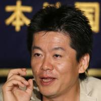 Takafumi Horie, the dot-com celebrity imprisoned for nearly two years on securities fraud charges, speaks during a news conference at the Foreign Correspondents’ Club of Japan in Tokyo in June 2013. NHK apologizes for Hitler-'No War' T-shirt worn by Takafumi Horie on air