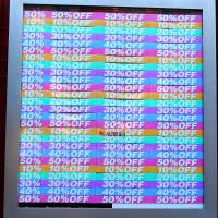 A shopper walks past a sale sign displayed at Hankyu Entertainment Park in Osaka on Wednesday. | BLOOMBERG