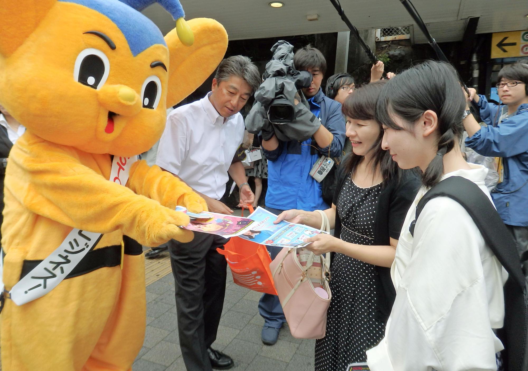 A Metropolitan Police Department mascot hands out leaflets warning about the dangers of the so-called JK business, in Tokyo's Harajuku district on Saturday. | KYODO