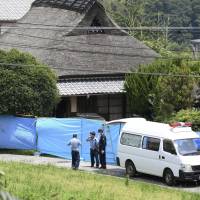 Police officers investigate a house where an elderly couple and a woman were found dead in Kobe’s Kita Ward on Sunday. | KYODO