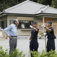 Police carry out an investigation in the grounds of a shrine in Kobe on Monday morning where Kanami Takeshima, a 26-year-old unemployed man, was arrested the previous day on suspicion of killing two of his grandparents and another elderly woman. Kobe man is handed fresh arrest warrant for allegedly murdering his grandfather