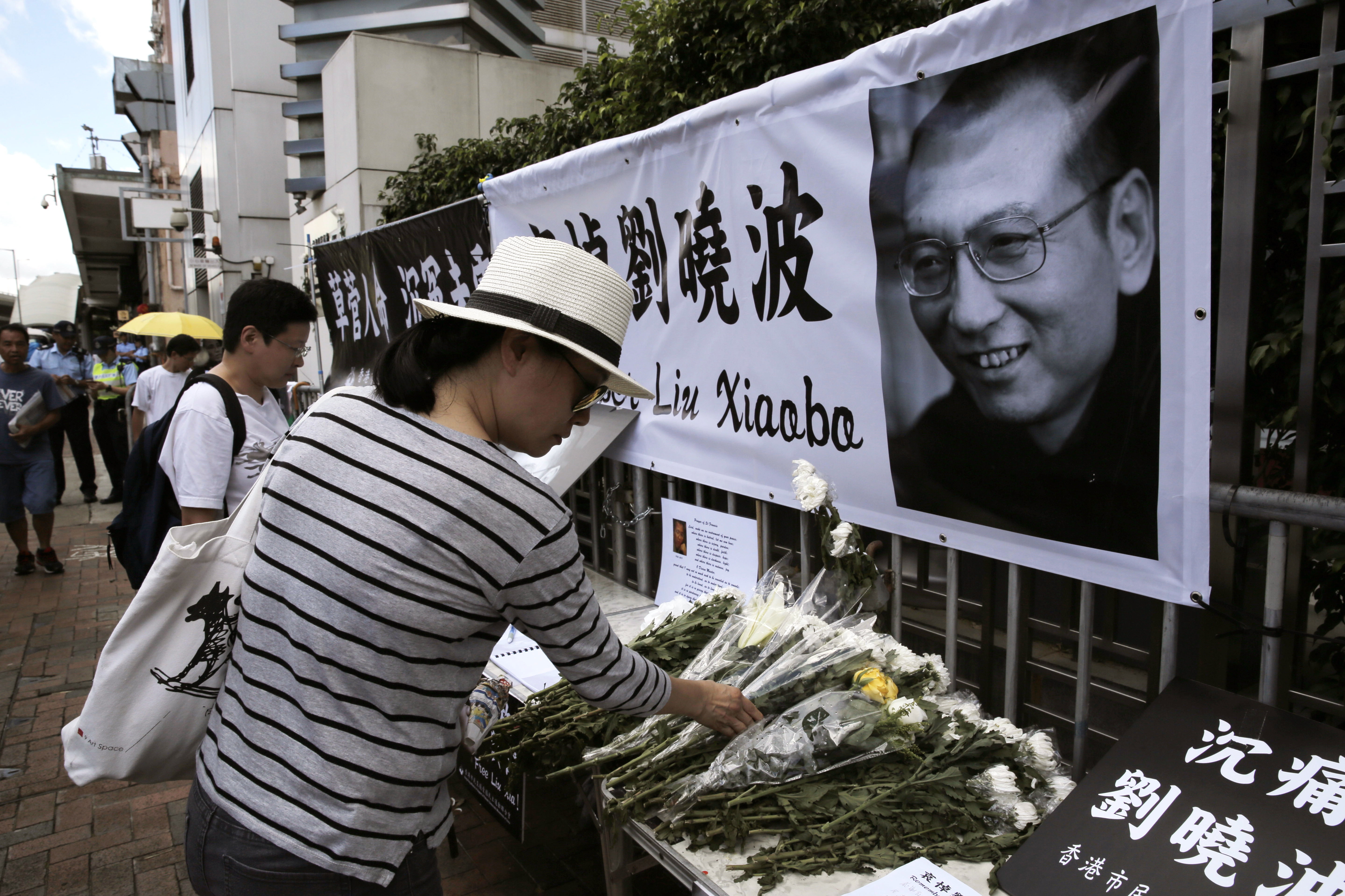 A woman mourns late Chinese Nobel Peace laureate Liu Xiaobo outside the Chinese liaison office in Hong Kong on Friday. | AP