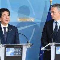 Prime Minister Shinzo Abe (left) and NATO chief Jens Stoltenberg speak during a news conference at NATO headquarters in Brussels on Thursday. | AFP-JIJI