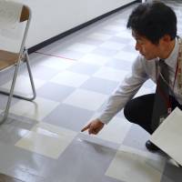 A worker at the Japanese Red Cross Kagoshima Hospital points out a crack in the floor caused by an earthquake on Tuesday. | KYODO