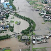The town of Oguchi in Aichi Prefecture is inundated by a flooded river on Friday after heavy rain pounded Aichi and Gifu prefectures. | KYODO