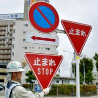 A traffic sign is replaced with a bilingual one in Osaka on Saturday. | KYODO
