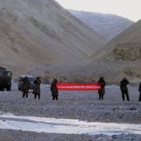 Chinese troops hold a banner that reads \"You\'ve crossed the border, please go back\" in Ladakh, India, in this May 2013 file photo. India announced Thursday that it is ready to hold talks with China if both sides pull back their forces to end a standoff over disputed territory high in the Himalayas. | AP