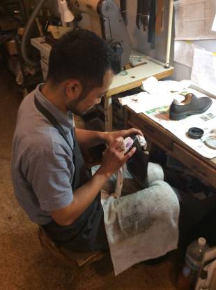 Apprentice Amane Yamaguchi polishes a pair of hand-crafted shoes.