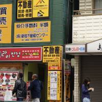 Open-door policy:  A real estate agency above a Korean restaurant in Tokyo\'s Shin-Okubo district \"welcomes  foreigners.\" | MAGDALENA OSUMI