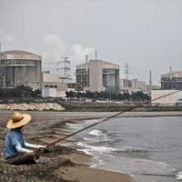 A man fishes in front of the Wolsong Nuclear Power Plant in Gyeongju, South Korea. Last month, President Moon Jae-in promised to scrap plans for new nuclear plants, not extend the life of existing ones, shut down 10 old coal power plants and cancel new coal projects. Learning from South Korea's energy breakthrough